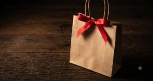 A small independent bakery counter where a staff member hands a customer a small gift box tied with ribbon, the customer looking genuinely pleased.